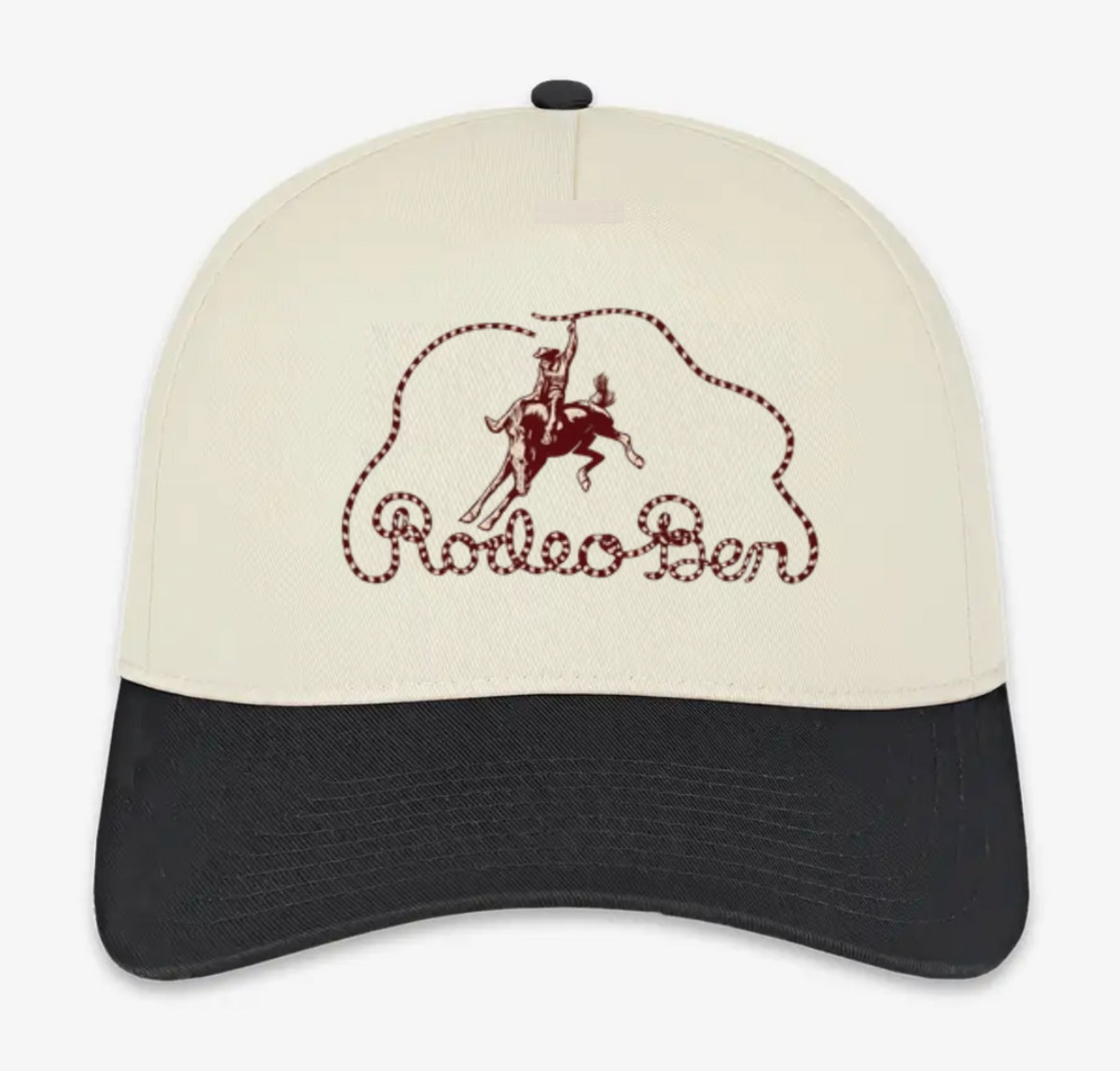 A structured baseball cap with an off-white crown and a black curved brim, featuring a dark red embroidered cowboy on a horse and the words 'Rodeo Bar' on the front.